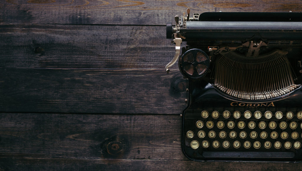 Photo of a typewriter sitting on a wooden table
