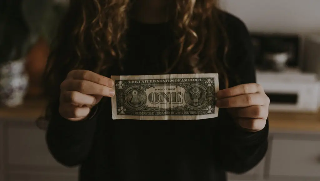 Photo of a young woman holding a dollar bill