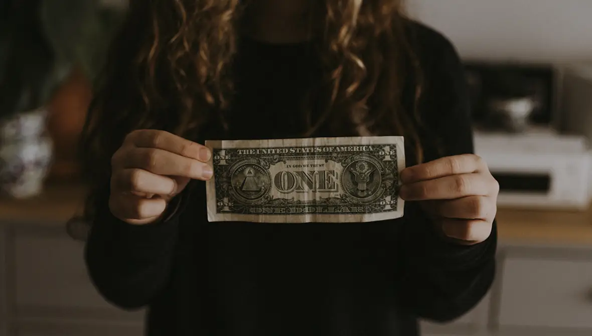 Photo of a young woman holding a dollar bill