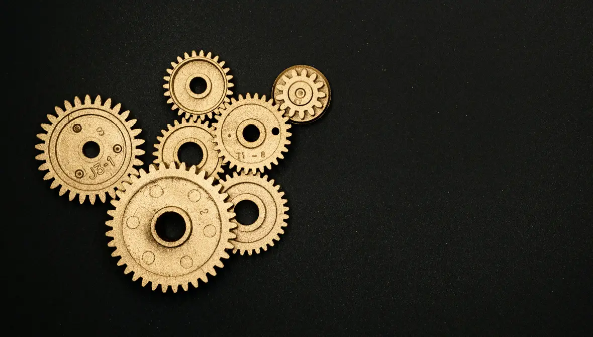 Photo of several brass interlocking gears on a black background