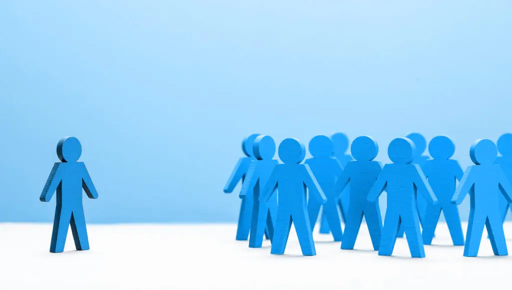 Illustration of a group of human figures all standing together and one figure standing separately off to the side