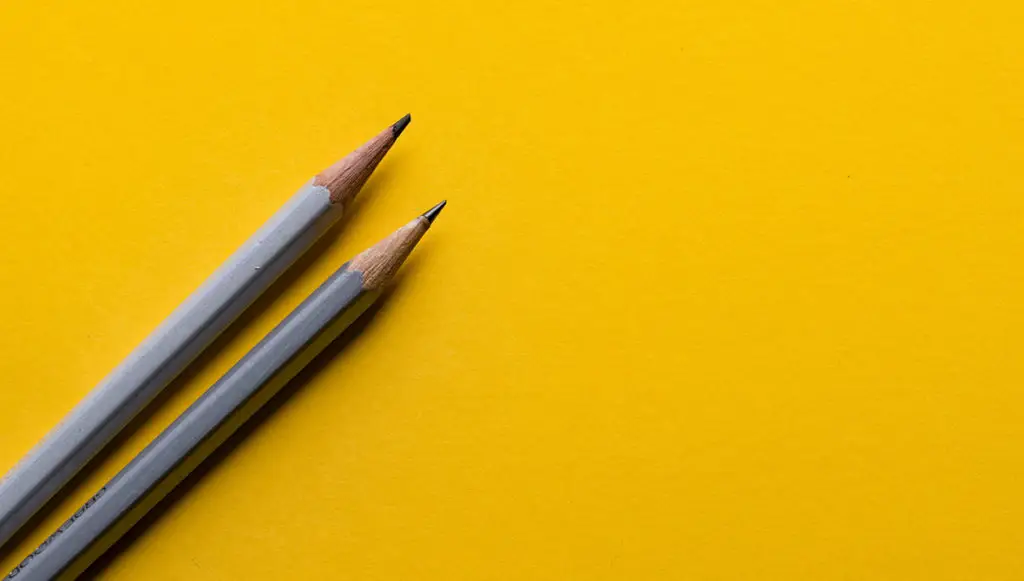 Photo of two sharpened pencils on a bright yellow background