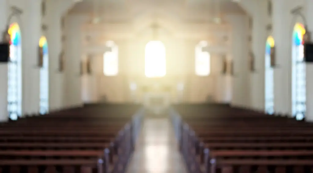 Photo of a church sanctuary showing rows of empty pews
