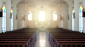 Photo of a church sanctuary showing rows of empty pews