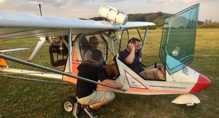 Photo of three men in a small prop plane preparing for takeoff