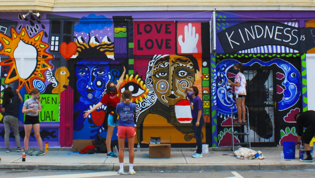A group of residents paints a colorful mural on the side of a building in Cleveland, Ohio.