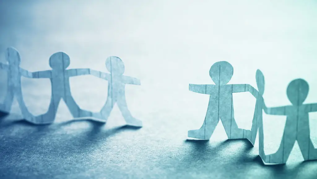 Photo of two chains of paper doll cut-outs next to each other with a gap between