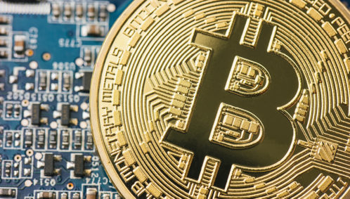 Close-up photo of the cryptocurrency Bitcoin resting on a computer circuitboard (Photo credit: Rafael Classen)