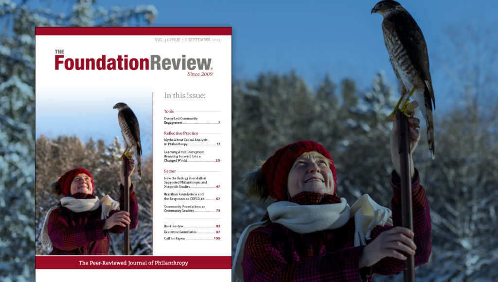 Front cover of The Foundation Review, vol. 13, issue 3 featuring a photo of Grand Valley State University professor Dr. Jenny Jenkins using a Cooper hawk on the university’s Allendale, Mich., campus to aid in her research on chickadees.