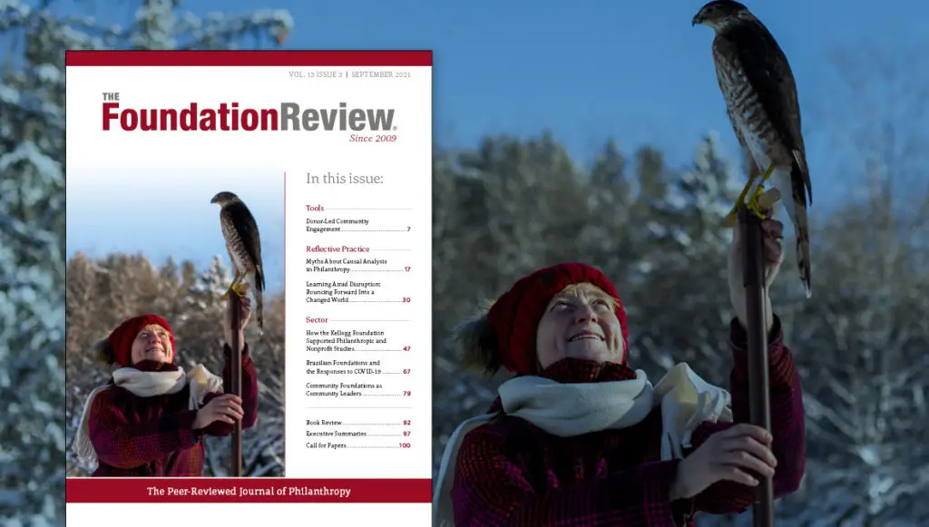 Front cover of The Foundation Review, vol. 13, issue 3 featuring a photo of Grand Valley State University professor Dr. Jenny Jenkins using a Cooper hawk on the university’s Allendale, Mich., campus to aid in her research on chickadees.