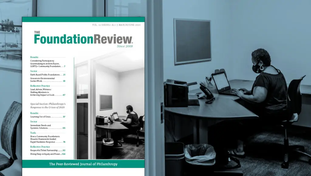 The front cover of The Foundation Review, volume 14, issues 1 & 2 is displayed over a background photo of Tiana Hawver answering a call as a volunteer for Grand Valley State University’s Virus Action Team call line in September 2020. Hawver is the office coordinator at the Dorothy A. Johnson Center for Philanthropy at GVSU. (Photographer: Kendra Stanley-Mills) The issue covers philanthropy's response to the crises of 2020.