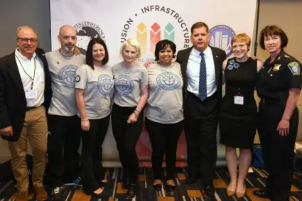 Formal photo of eight AmeriCorps members serving in the Police Assisted Addiction & Recovery Initiative (PAARI)