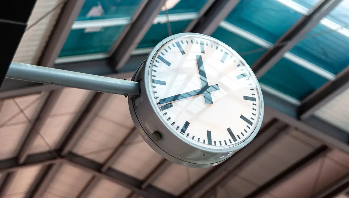 Close-up photo of a large, analog clock at a train station