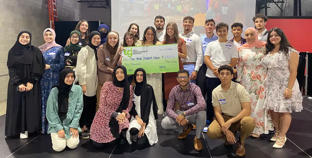 A group of young people in CAAP's Teen Grantmaking Initiative poses with a giant check The program supports Arab American giving.