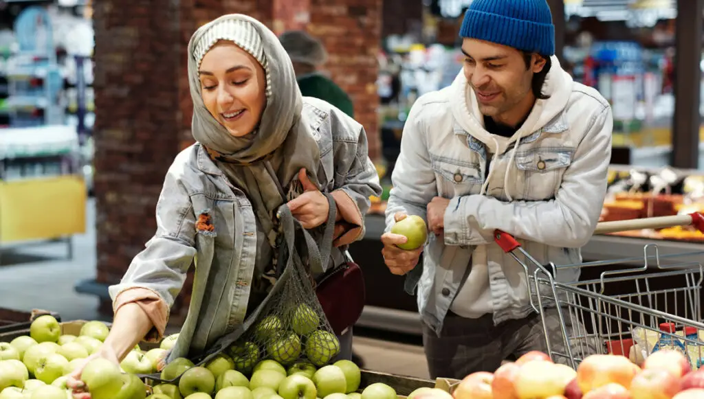 A Middle Eastern/North African (MENA) couple shops for produce in an American grocery store.