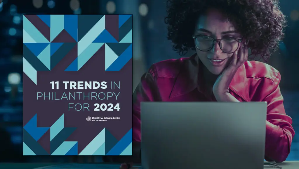 The front cover of the 2024 Trends report is featured over a background photo of a Black woman smiling and looking at a laptop, as if reading the report.