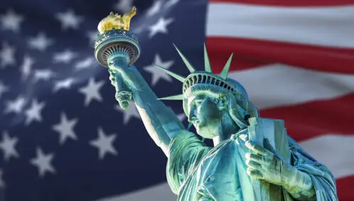 The Statue of Liberty on a background of the American flag