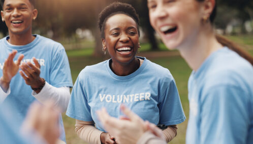 Three smiling adults wearing shirts that say "Volunteer"