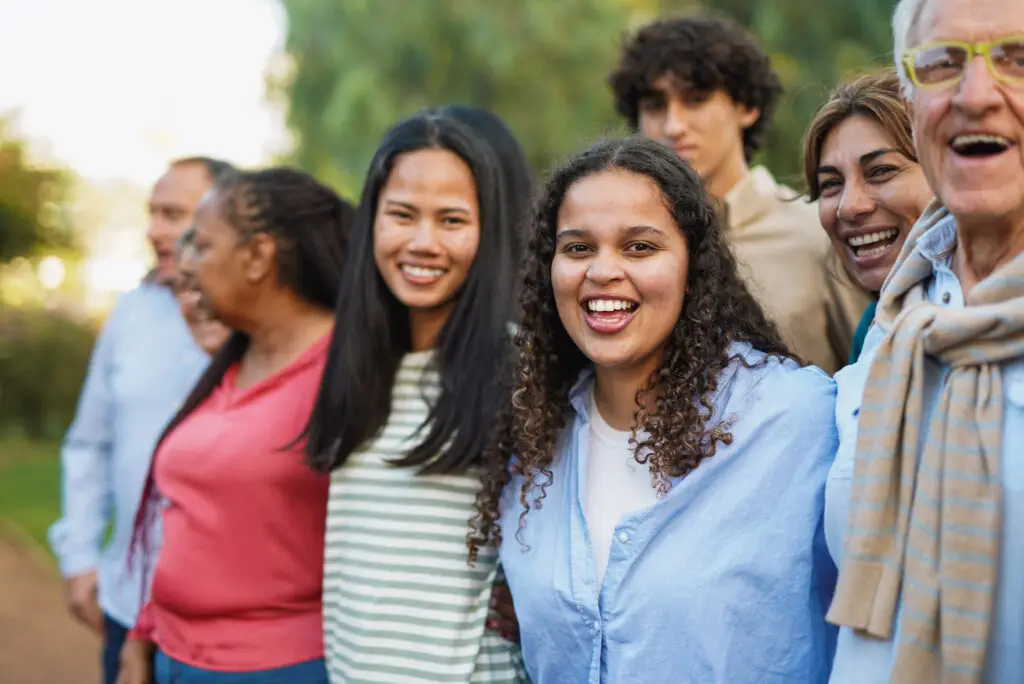A diverse group of smiling people standing in a park